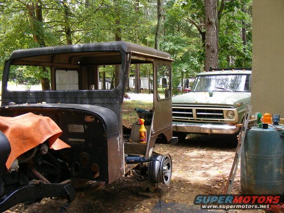 Jeep CJ-5 body in foreground, green Ford F-Series truck behind it