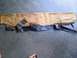 1994 Ford Bronco - A car part, possibly a trim piece, is laid out on a concrete surface with torn brown paper and black tape.