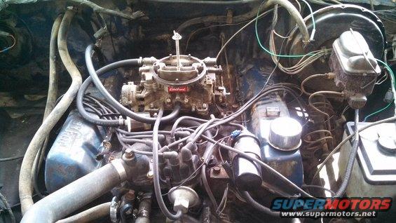 Engine bay showing carburetor, distributor, and brake fluid reservoir