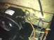 2003 Ford Crown Victoria - A close-up view of a compressor and its associated wiring, mounted on a bracket.