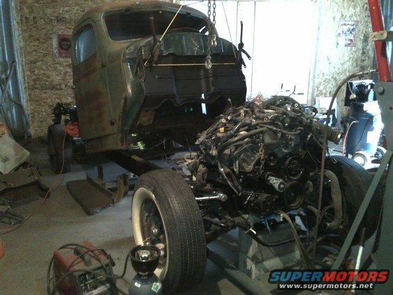 Truck chassis in garage with engine assembly and welding equipment