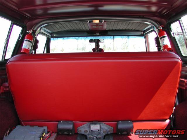 Red rear seat with fire extinguishers mounted on the interior sides