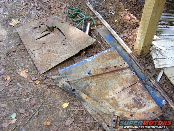 Rusted metal car door and panel pieces on the ground