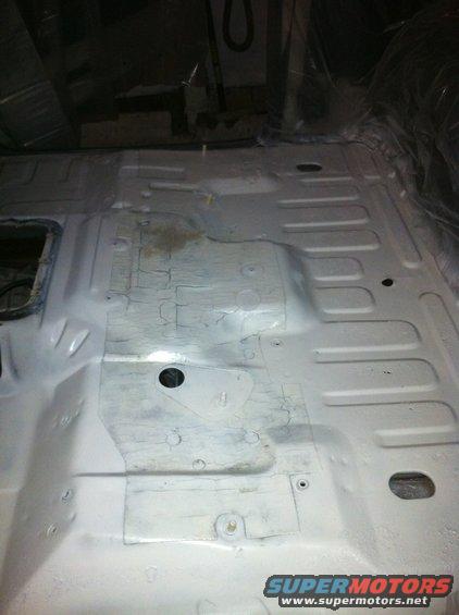 Interior floor pan of a vehicle, showing structural ribs and mounting points