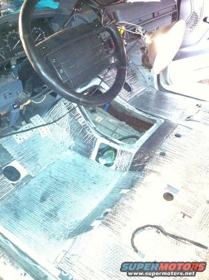Interior of a 1992 Ford Bronco with soundproofing material on the floor and center console removed