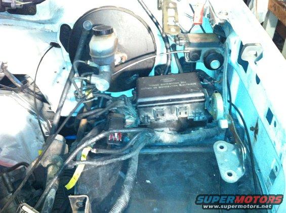 Engine bay showing brake master cylinder, fuse box, and wiring harness