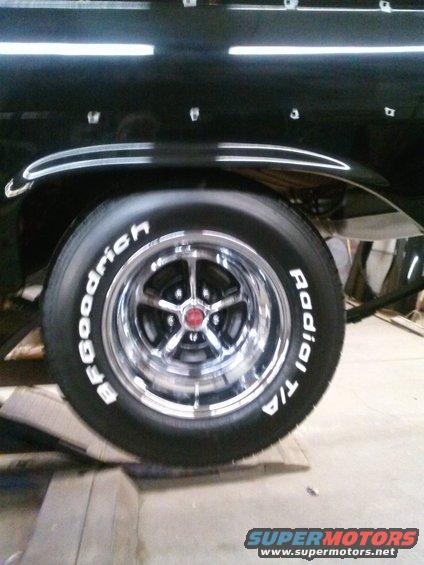 Black car fender with chrome trim above a chrome five-spoke wheel with BFGoodrich Radial T/A tires