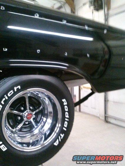 Black car rear quarter panel with chrome trim and a chrome five-spoke wheel with BFGoodrich Radial T/A tires