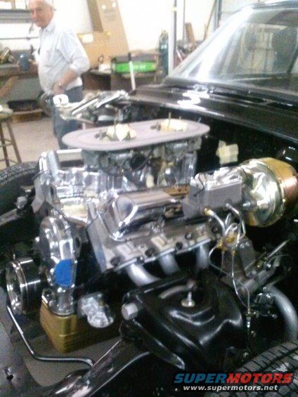 V8 engine with dual carburetors and chrome valve covers in an engine bay