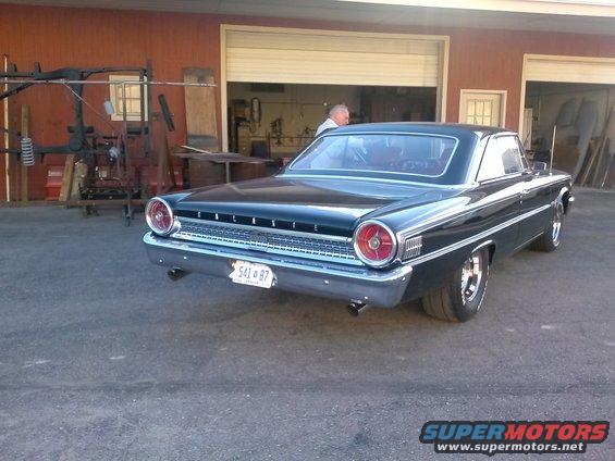 Black 1963 Ford Galaxie 500 coupe, rear view, parked outside a garage