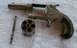 1968 Mercury Cougar - A disassembled revolver, showing the frame, cylinder, and ejector rod, resting on a textured surface.