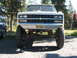 1989 Chevrolet C/K Pickup - This lifted 1989 Chevrolet C/K Pickup features a prominent grille and large off-road tires.