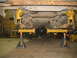 1989 Chevrolet C/K Pickup - Underside view of a rear axle assembly, painted yellow and supported by jack stands, undergoing work.