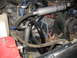 1989 Chevrolet C/K Pickup - Close-up view of an engine bay showing various hoses, wiring, and engine components, including a silver canister and black tubing.