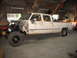 1989 Chevrolet C/K Pickup - A white crew cab pickup truck is parked inside a garage with its front end partially dismantled.