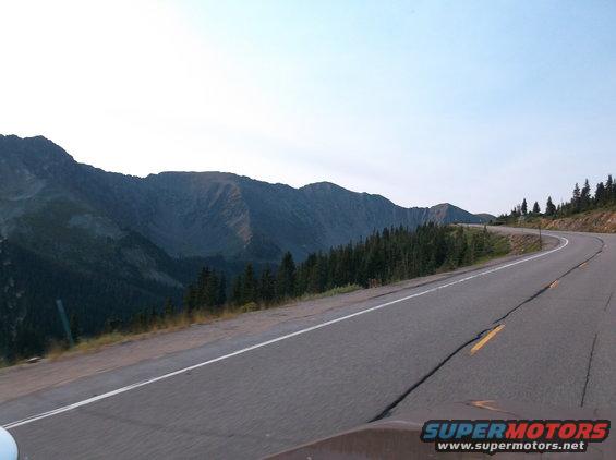 Winding mountain road with trees and sky