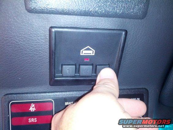 Close-up of car interior buttons with a finger pressing one labeled '3'