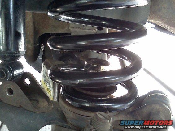 Black coil spring and shock absorber assembly on a vehicle's suspension