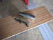 2005 Ford Excursion - Two chrome bumper guards are laid out on a wooden surface, with a red tool in the background.