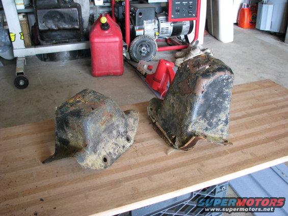 Two heavily rusted, yellow-primed metal parts sit on a wooden surface
