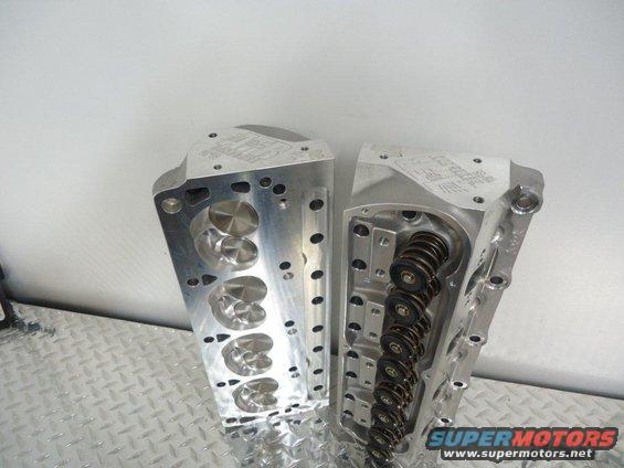 Pair of aluminum engine cylinder heads with visible valves and springs