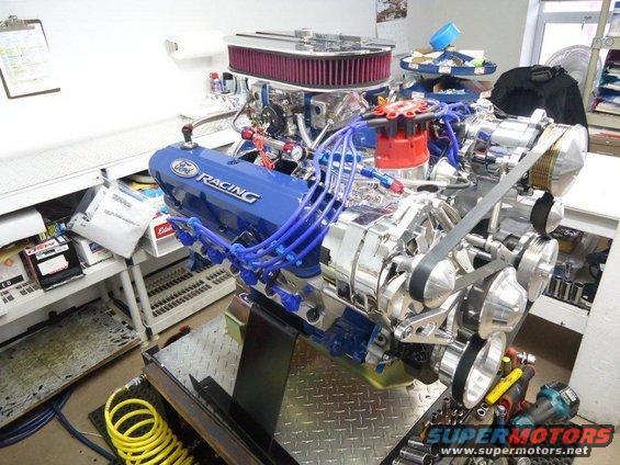 Blue Ford Racing V8 engine with chrome components and red distributor cap, on a stand