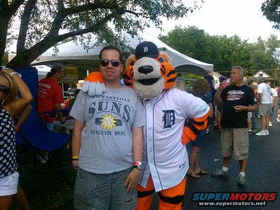 Man in gray Jacksonville Suns t-shirt and shorts with mascot in baseball uniform
