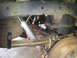 2003 Nissan Frontier - Close-up view of the rear suspension system of a vehicle, showing leaf springs and a shock absorber.