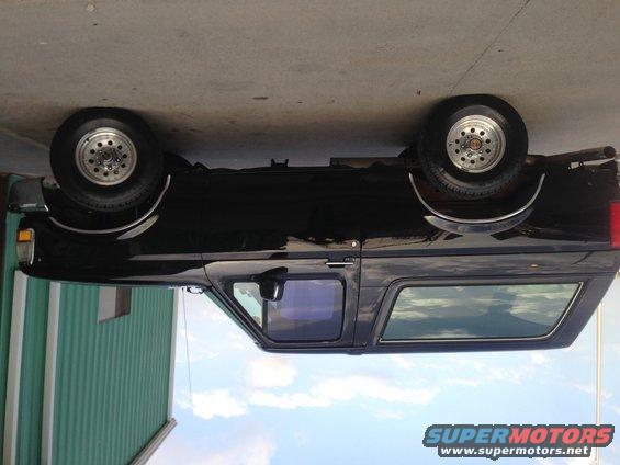 Black 1992 Ford Bronco parked next to a green building