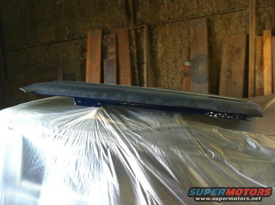 Dark dashboard part with chrome trim, covered in plastic sheeting