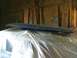 1982 Ford Bronco - A dark dashboard component, possibly for a classic vehicle, is covered in plastic sheeting in a workshop.