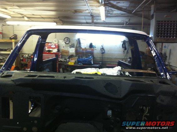 1978 Ford Bronco body shell, blue and white, undergoing restoration in a workshop