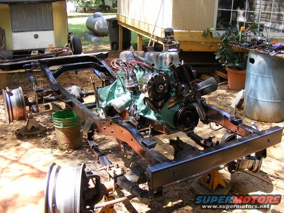 Vehicle frame and engine assembly on jack stands outdoors
