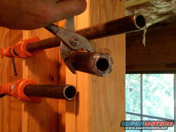 Two different sized clamp pipes put inside one another with a sledge