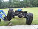 1992 Ford Bronco - The chassis of a vehicle, large off-road tires and a blue engine, is shown from the front. A Supermotors.net logo is visible in the lower r…