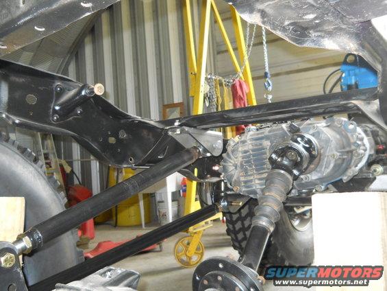Undercarriage view of transfer case and driveshaft, SuperMotors.net logo visible