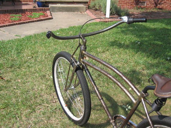 Rusty bicycle frame with brown leather seat and handlebars