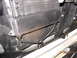 1979 Ford F-150 - Close-up view of a transmission cooler, likely an OE Ford part, showing its finned construction and plumbing.