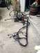 2004 Ford Crown Victoria - Engine wiring harness lies on a concrete surface, with a bicycle and stacked tires visible in the background.