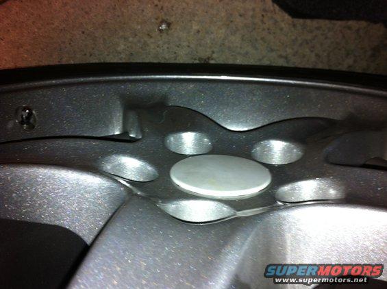 Close-up of a car's wheel hub with lug nut holes and a center cap