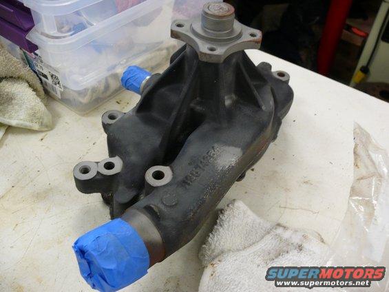 car water pump with blue tape on outlets, sitting on a workbench