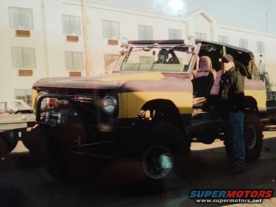 Yellow and maroon Ford Bronco with off-road modifications