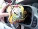 1999 Mercury Grand Marquis - The airbag module is being removed from the steering column, revealing its internal wiring and mounting bracket.