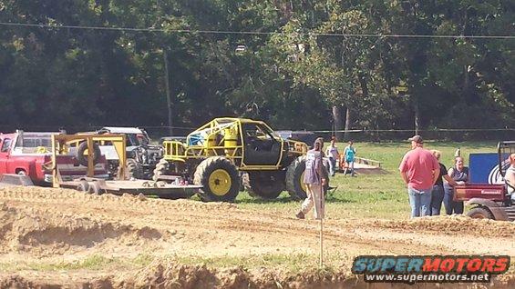 Yellow custom off-road truck with roll cage and large tires