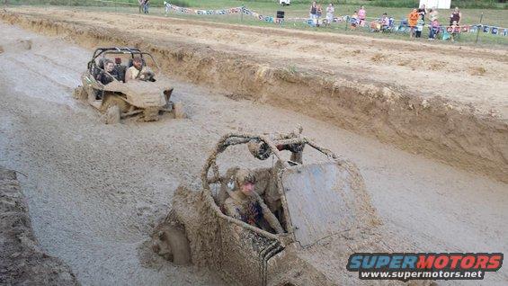 Mud bog racing with two off-road vehicles stuck in thick mud