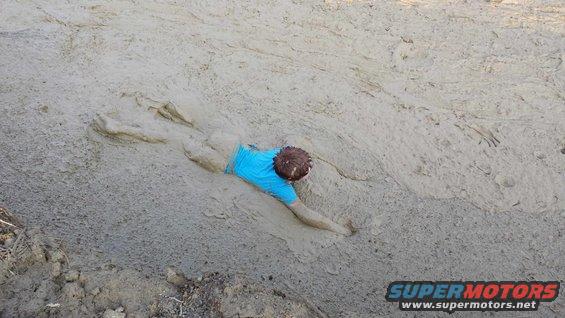 Person stuck in mud, blue shirt, Supermotors logo in corner