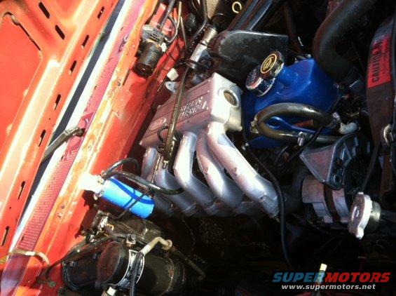 Engine bay with silver intake manifold and blue valve cover