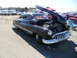 1973 Ford Ranchero - A classic black sedan is displayed with its hood open, a 'For Sale' sign visible on the windshield.