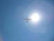 1973 Ford Ranchero - An airplane is seen flying against a bright sun in the sky.