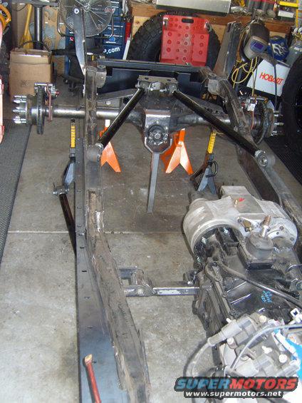 Jeep CJ frame on jack stands, showing suspension and transmission
